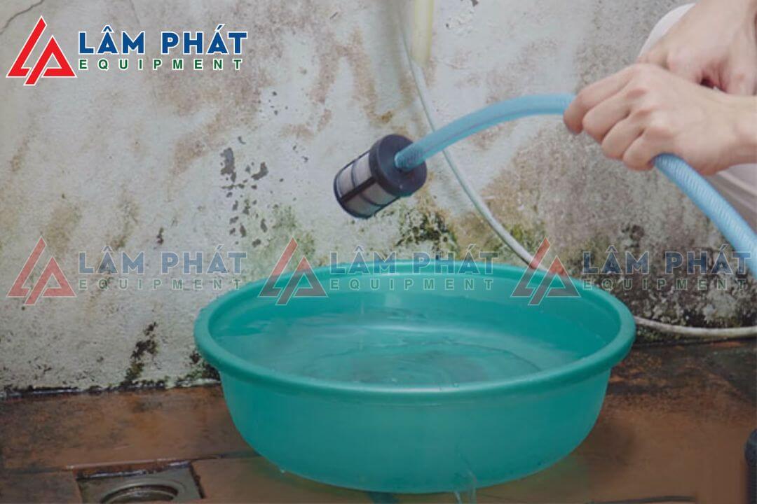 Thả đầu dây hút nước vào chậu nước, nguồn nước